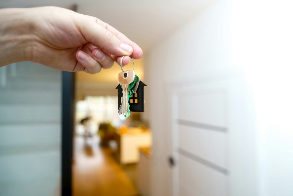 A hand holding house keys with a house keyring, representing a completed property sale won through estate agent SEO