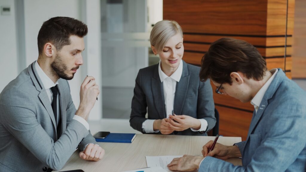 Solicitors reviewing and signing legal documents with a client, representing the expertise and trust behind a law firm online presence