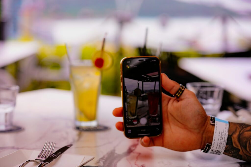 A diner using a phone at a restaurant table, representing how customers find restaurants on Google