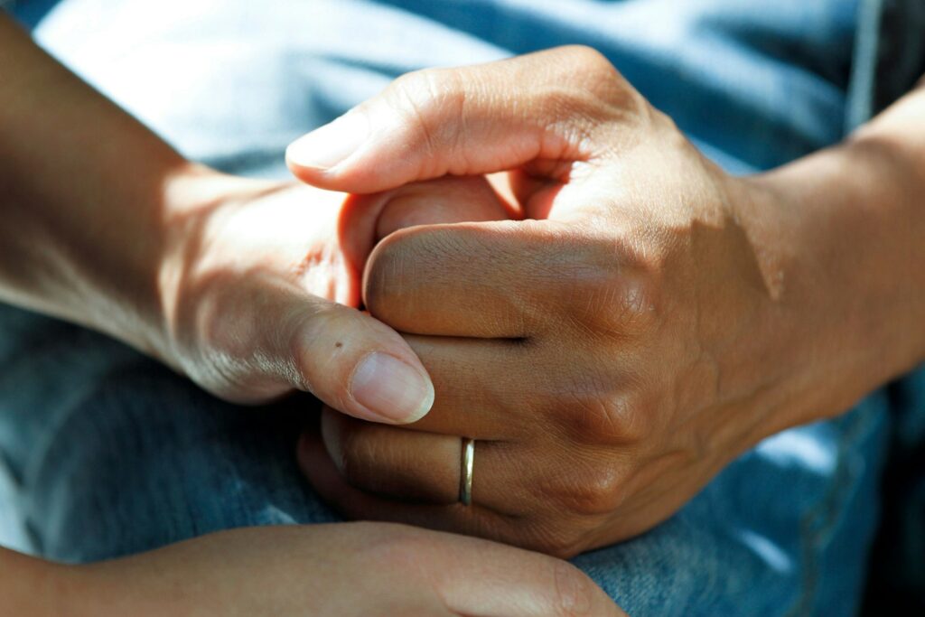 A clinician holding a patient's hands, representing the trust and patient care at the heart of healthcare and private clinic SEO