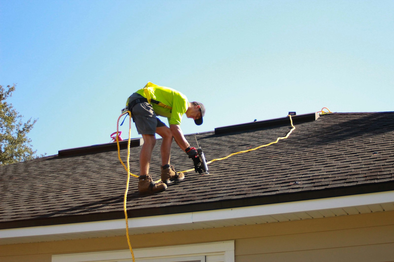 Roofer working on a UK roof with a power drill, representing roofer SEO and roofer near me searches
